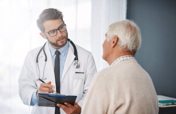GP speaking with an older patient during a consultation, representing the importance of clinical input in AI GP reception systems like EMMA by QuantumLoopAI to ensure safe, accurate, and NHS-compliant communication.