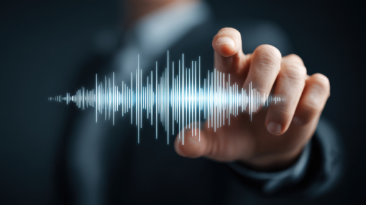 Hand reaching toward a digital soundwave, symbolising the limitations of transcription technology and how EMMA by QuantumLoopAI uses advanced AI voice systems to improve accuracy and understanding in GP surgeries.